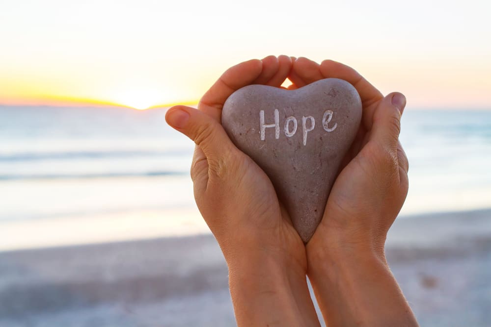 hands hold a stone of hope finding hope in hopelessness